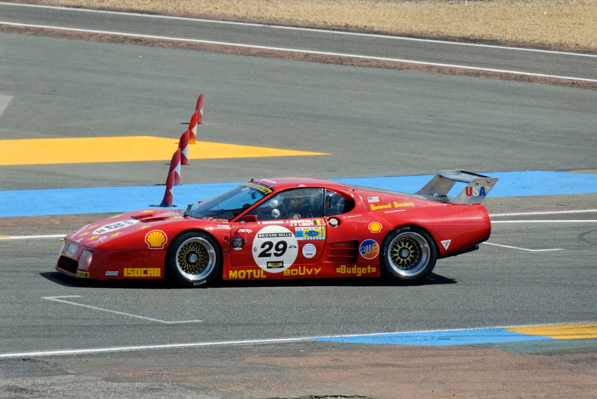 A red Ferrari 512 BB LM, number 29, in profile on the Le Mans circuit.